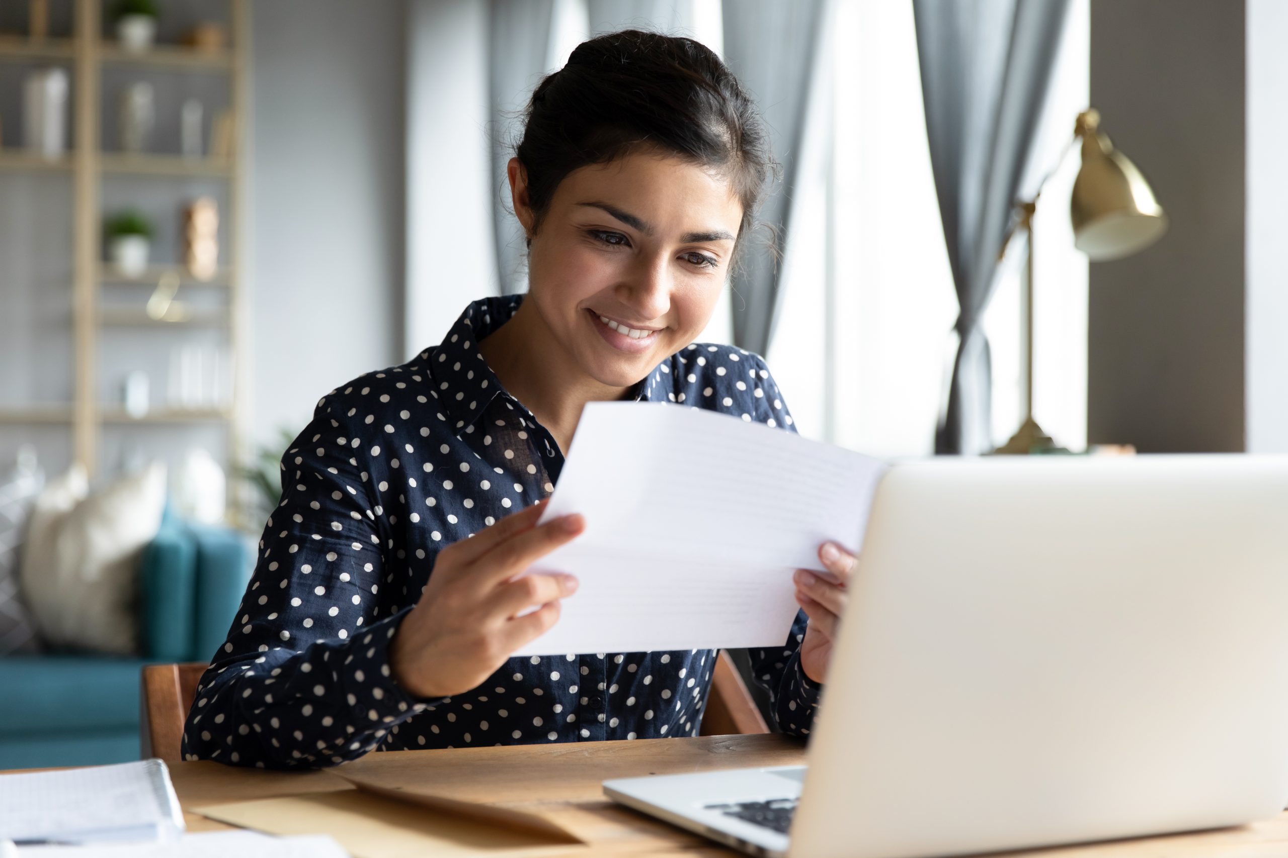 Smiling,Young,Indian,Woman,Holding,Paper,Bill,Letter,Doing,Paperwork